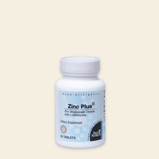 Supplement bottle labeled 'Zinc Plus II' on a beige background